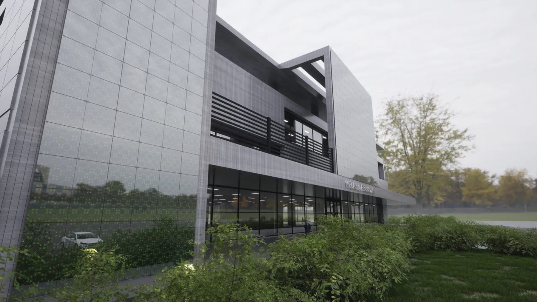 Glass-and-stone commercial building seen from the approach