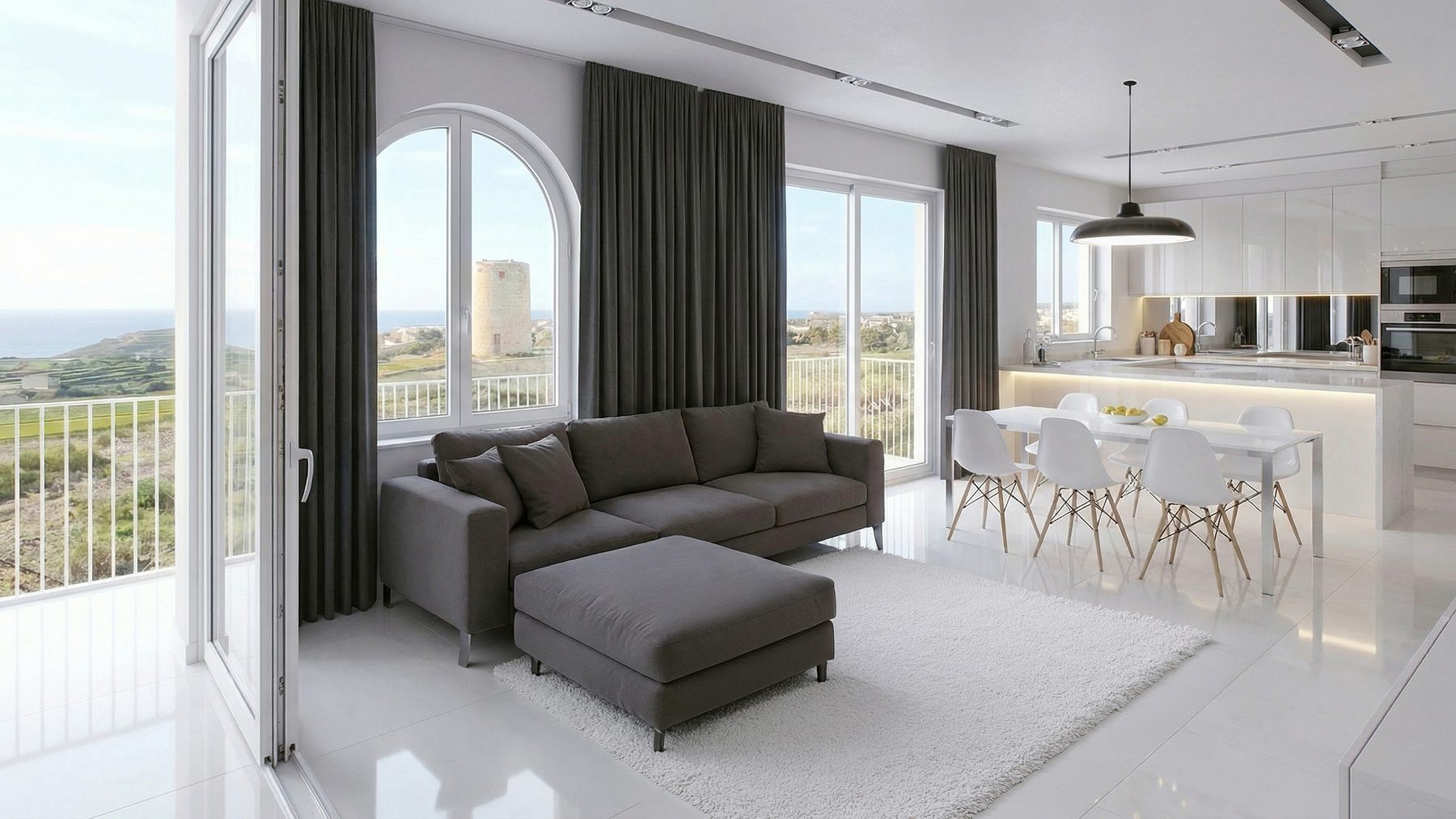 Living room with an arched window framing fields, the sea and a historic tower